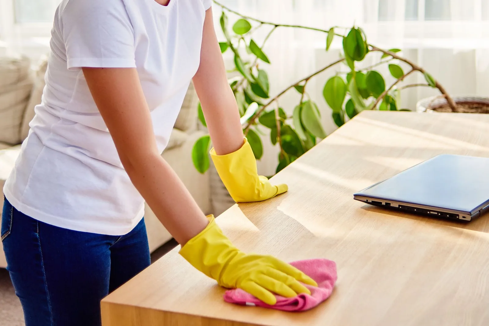 A professional cleaning a desk in a bright office